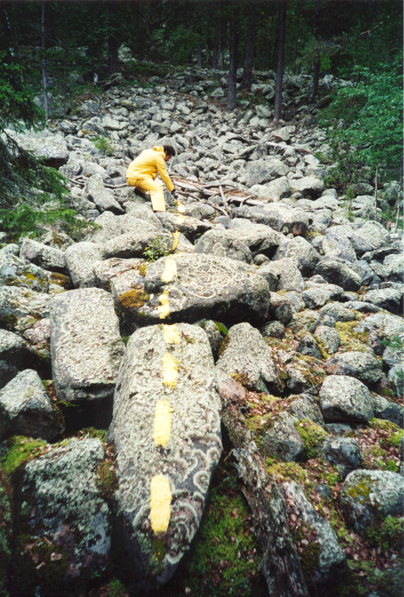Toni Kleinlercher drawing a yellow line across rocky terrain at the Arctic Circle
