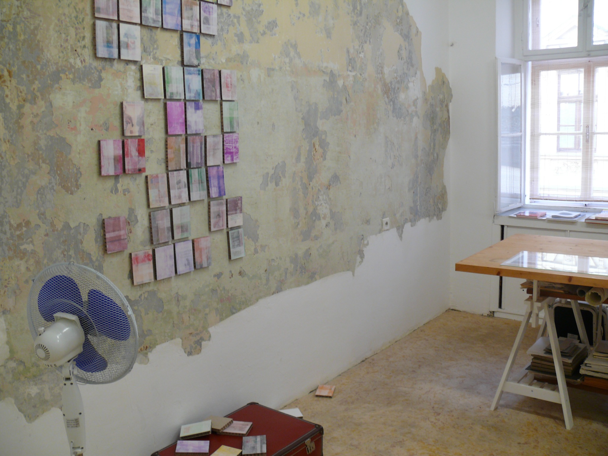 Installation view showing the electric fan, suitcase and cover paintings